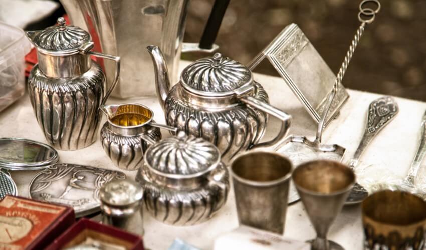 silver teacups, pots, and serving dishes on display
