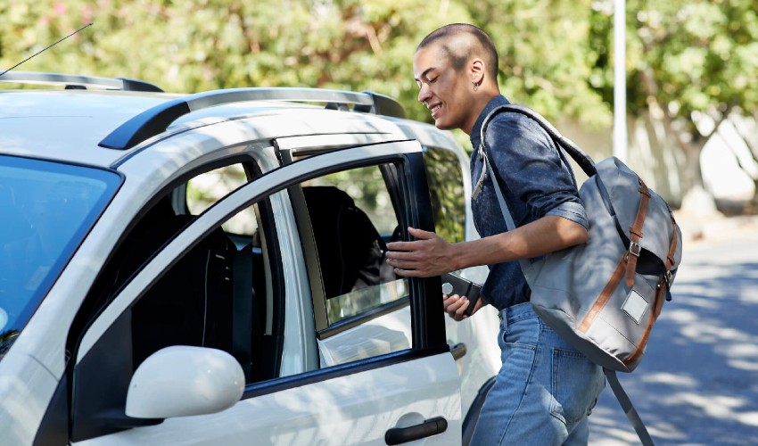 Man entering drivers side of car sharing vehicle.