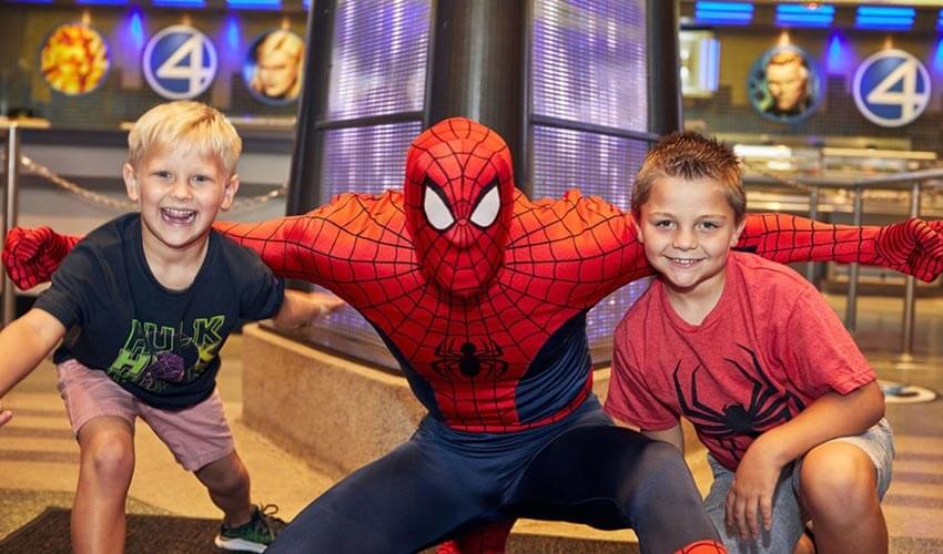 Spiderman posing in a picture with two children.