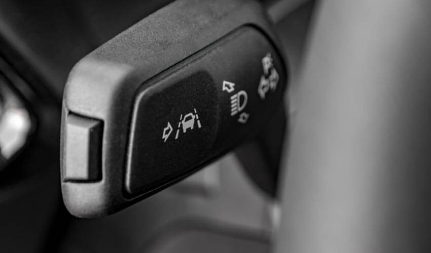 A switch behind the steering wheel to activate lane keeping assist feature.