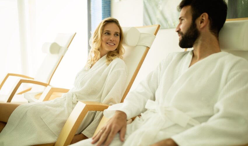A man and woman relaxing on chairs at a spa.