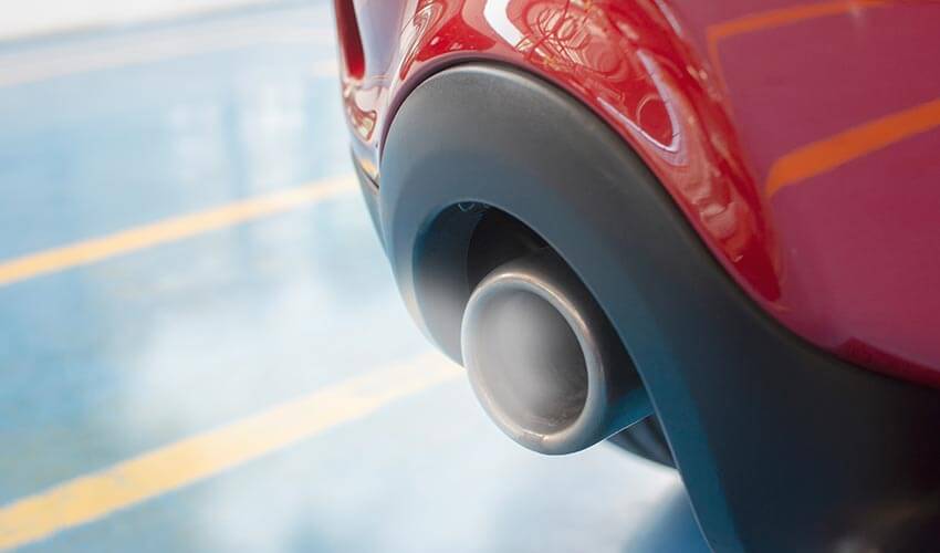 Smoke emitting from car exhaust pipe.