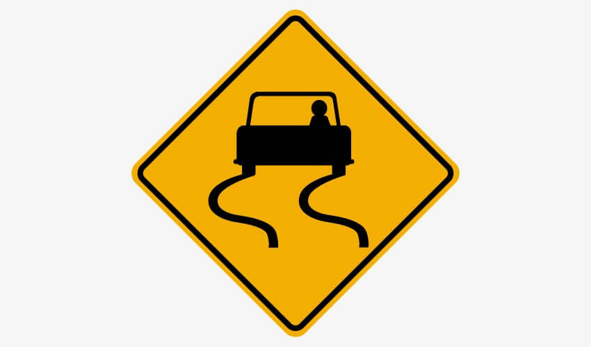 A road sign warning drivers of a slippery road.