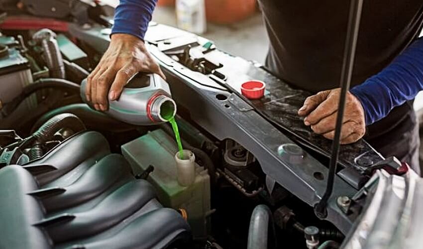 Mechanic fills engine oil into a car engine.