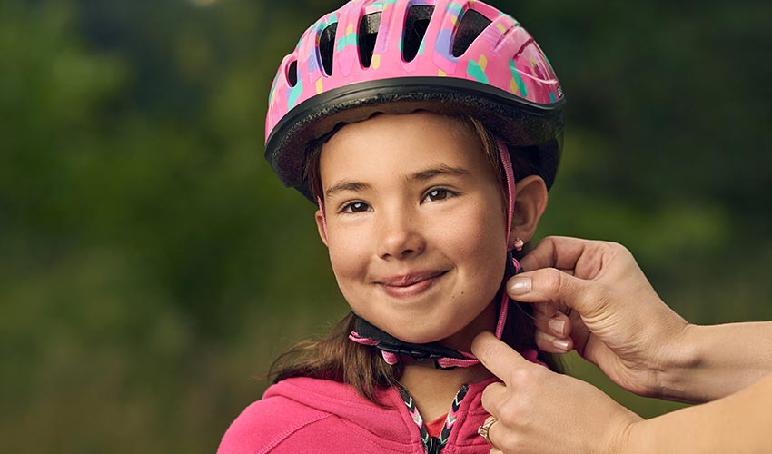 Securing bike helmet on a child.