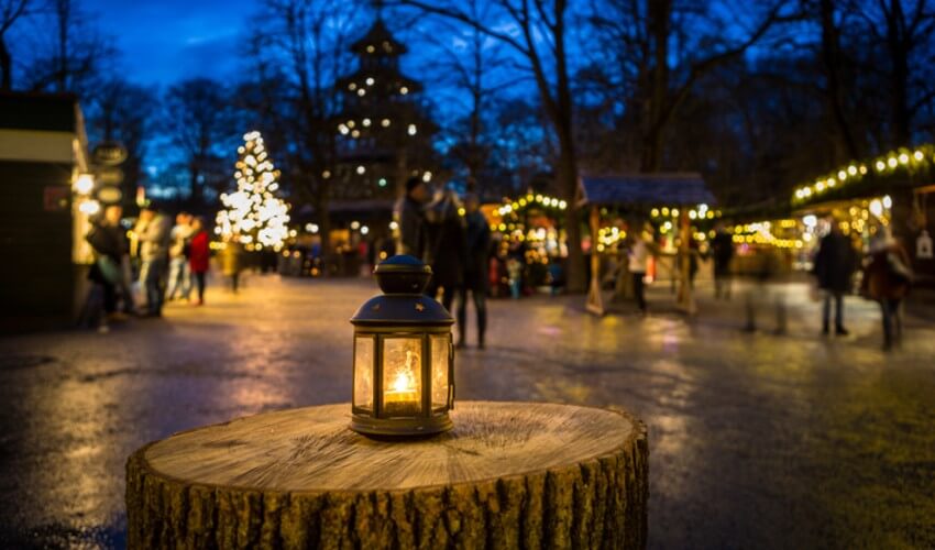Close-up of a lamp on a long outside a Christmas market.