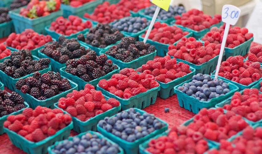 Strawberries and blueberries on display at a market.
