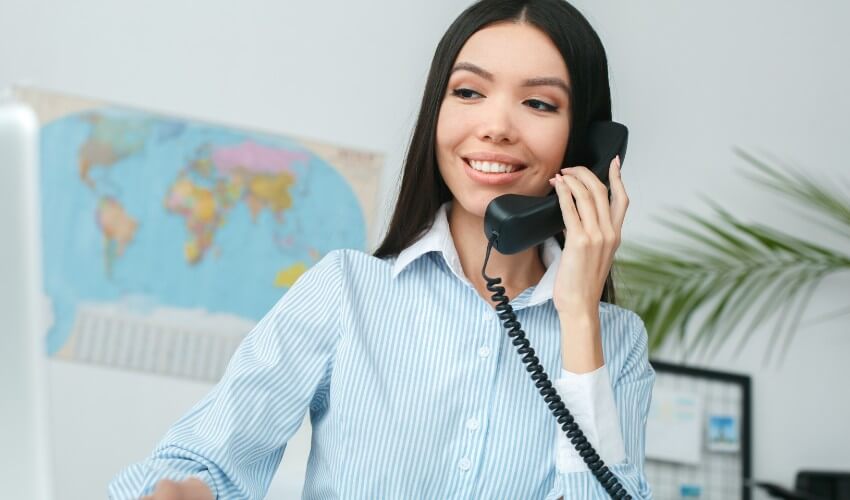Female travel agent on the phone with a customer.