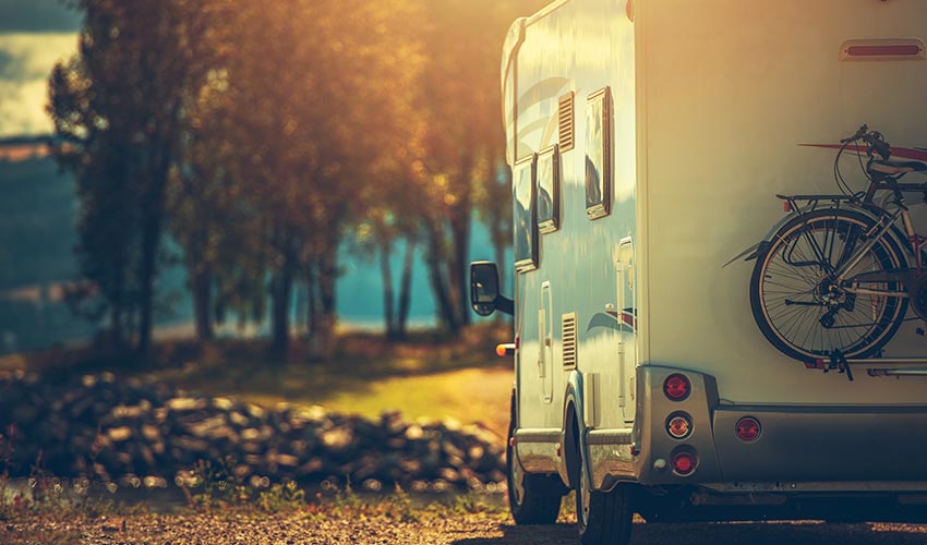 A parked RV with a fall background. 