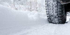 A tire is shown on a snow-filled road