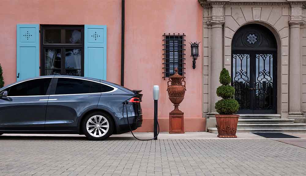 A car is parked on a street at a charging station