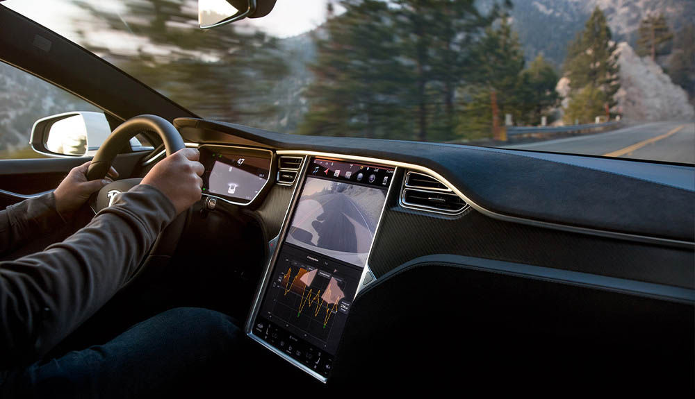 a screen on the dash of a Tesla displays data