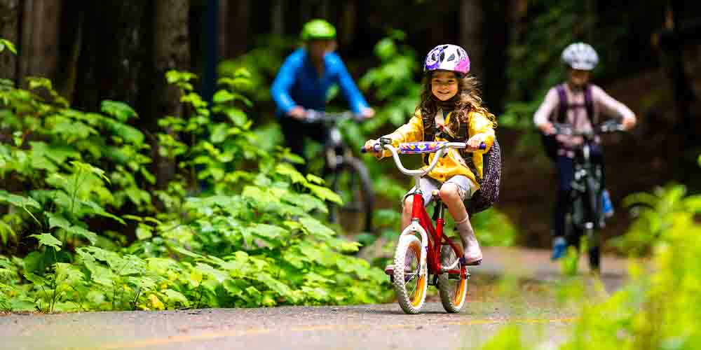 Kids ride their bikes on a path outdoors