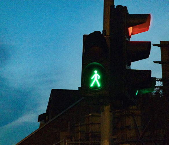 A pedestrian crossing light that is green, showing that it is okay for pedestrians to cross the road.