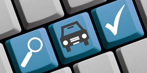A grey keyboard with 3 blue keys; one with a search icon, one with a car icon and one with a checkmark.