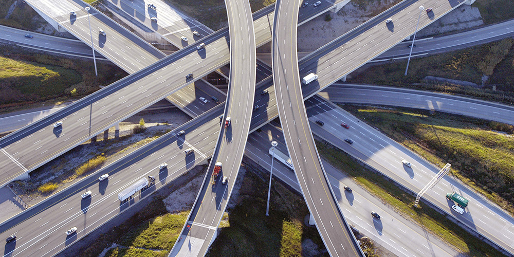 An overhead view shows several overlapping overpasses for highways