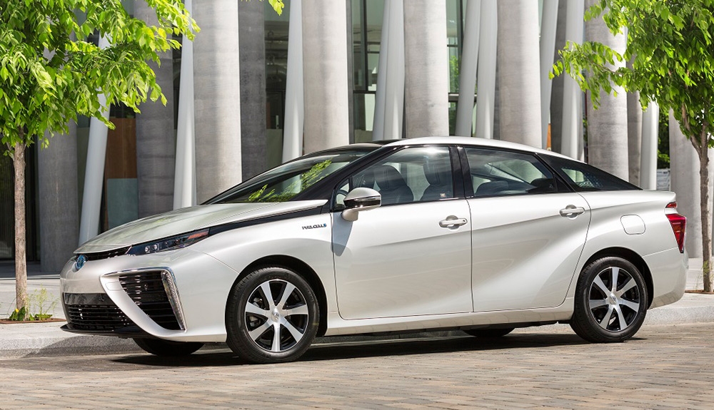 Toyota Mirai parked on the street between two small, young trees