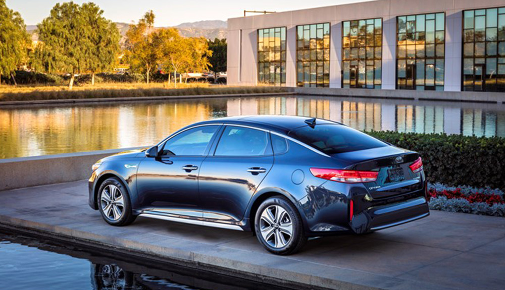 Black Kia Optima HEV Hybrid parked facing a body of water on a dock