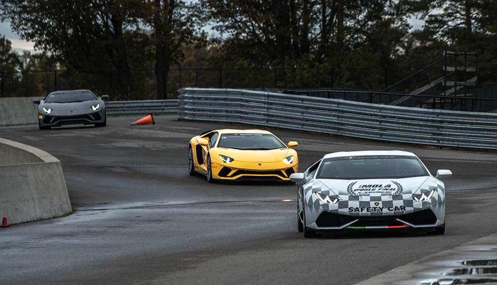 White checkered, yellow and black Lamborghinis speed down a race track