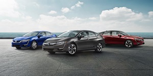 Blue, black and red 2018 Honda Clarity hybrid-electric sedans parked outside near water