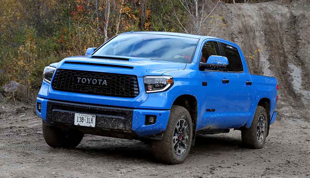 Blue muddy Toyota Tundra on a dirt road 