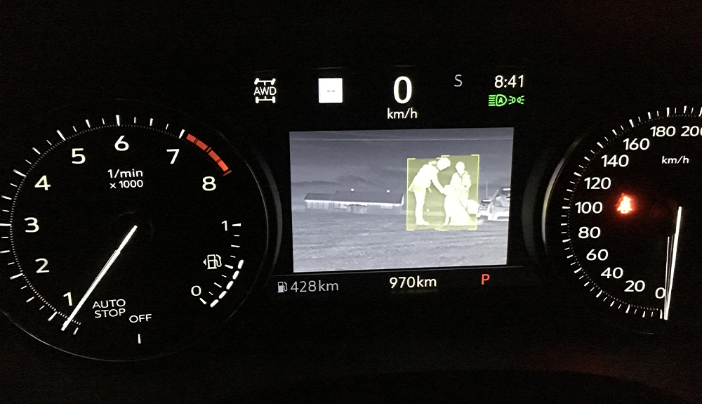 The night-vision camera on the dash shows the silhouette of a person and a dog