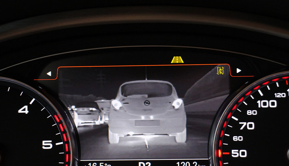 A dashboard screen shows the night vision camera as it captures cars nearby