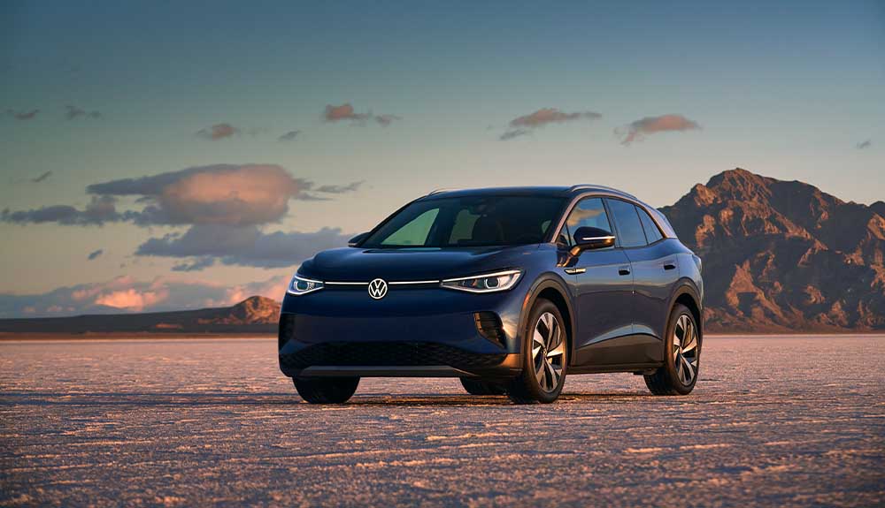 A black 2022 Volkswagen ID.4 is parked in the dessert with mountains in the background
