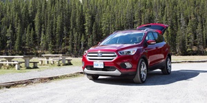 Red 2017 Ford Escape compact SUV with the trunk up outside with mountains in the background