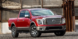 Red 2016 Nissan Titan XD Platinum Reserve parked in an industrial setting