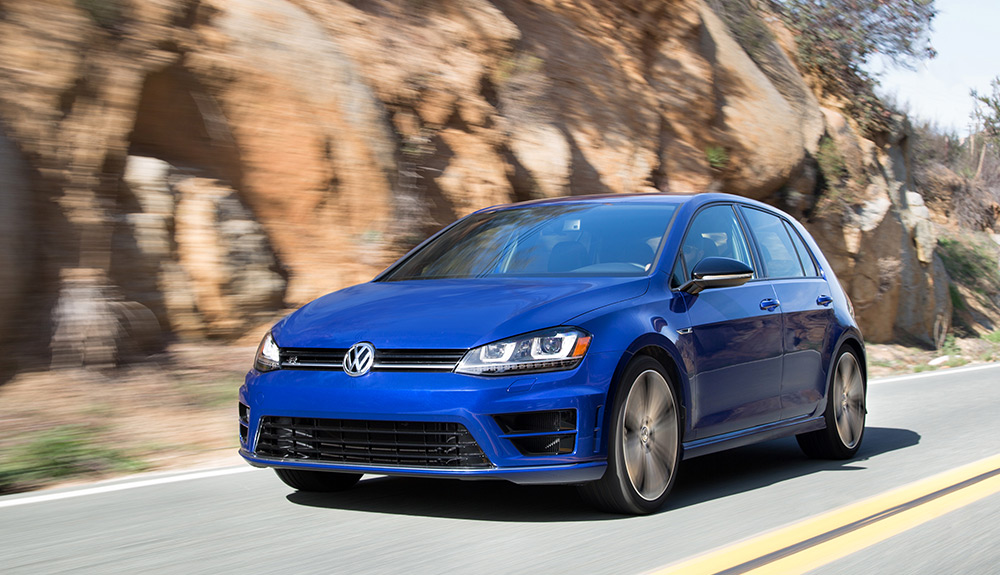 Dark blue Volkswagen Golf R speeding down a rocky landscape