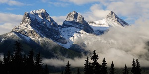 The snow-topped Rocky Mountains are seen in the mist on a bright, blue day in Canmore, Alberta 