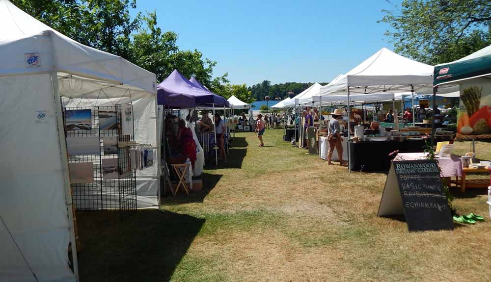 Stalls and tents are set up at a farmer's market