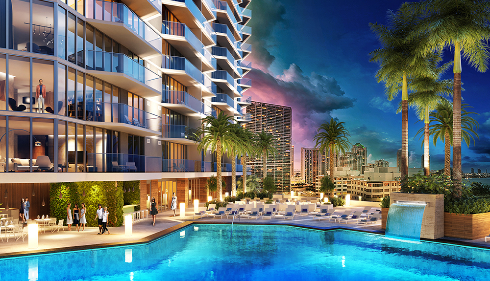 A right night shot of the Hyatt Centric Brickell Miami hotel exterior, pool glittering in the light