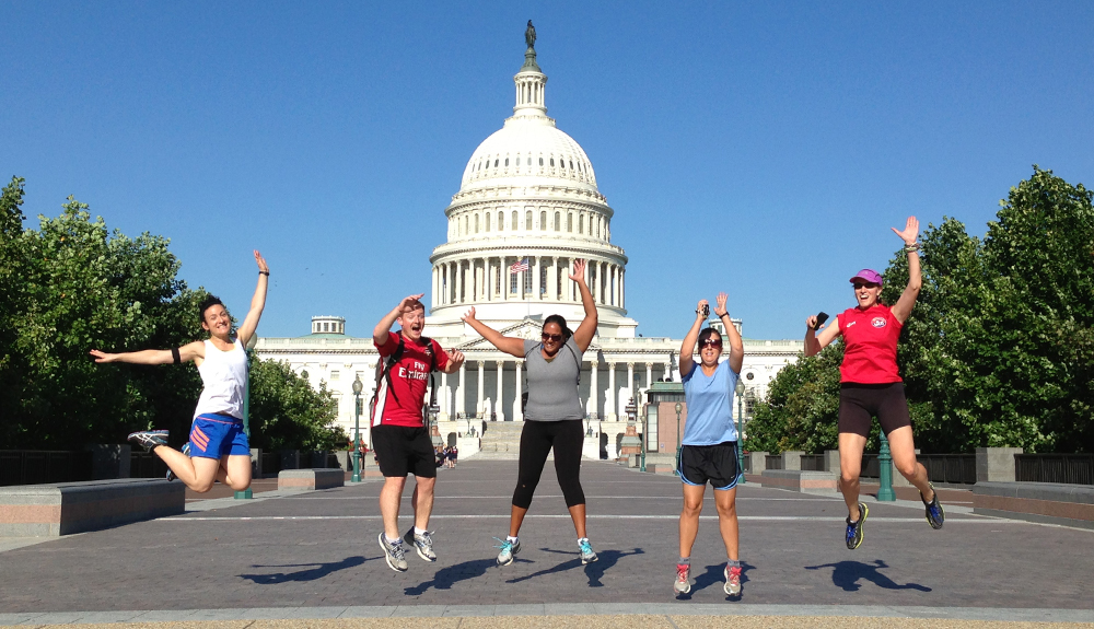 Five people jump in the air in front of Washington landmark
