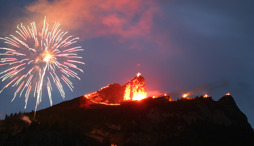 Fireworks light the sky as the Sacred Heart Fires blaze in the Austrian Alps