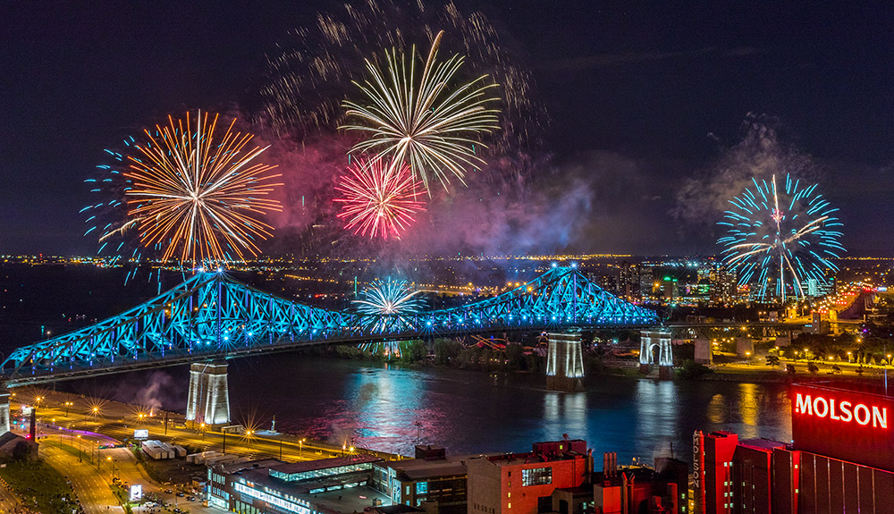 A firework display is seen at night over the Jacques-Cartier Bridge in Montreal