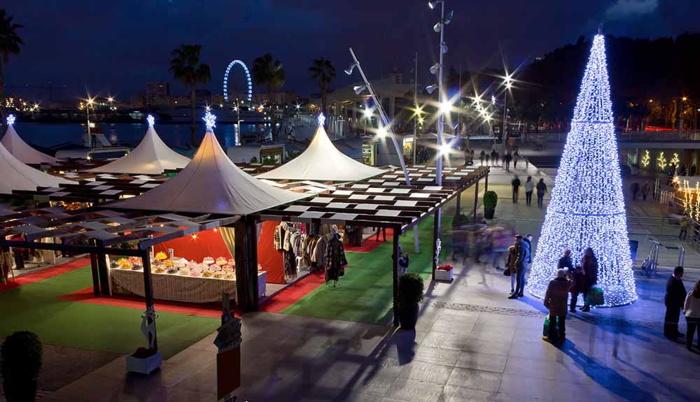 Tents and a tree made of lights are on display at a street festival in Malaga, Spain