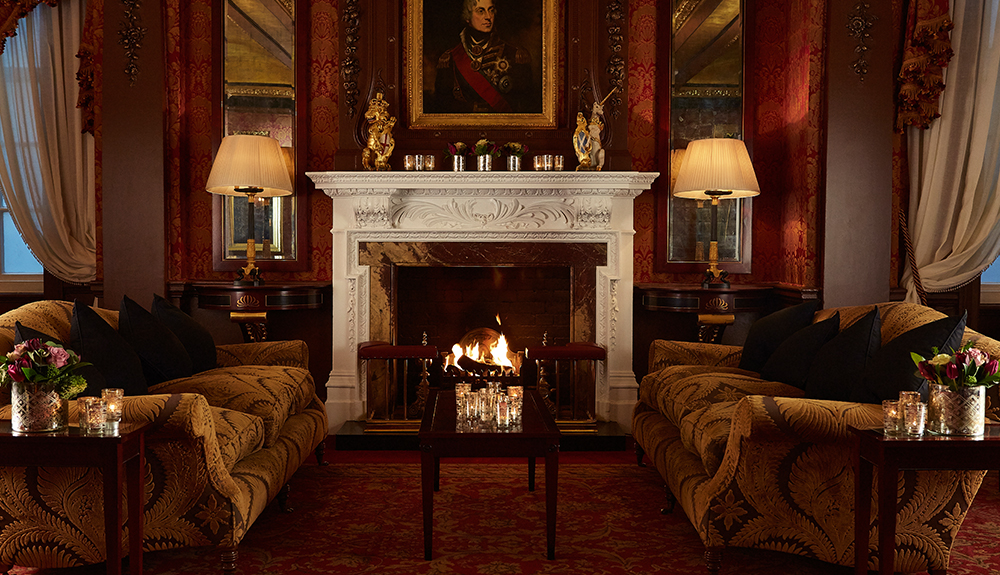 Two couches face each other with a fireplace in the center at The Goring