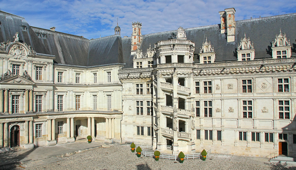 An exterior shot of the stately white Chateau de Blois with a black roof