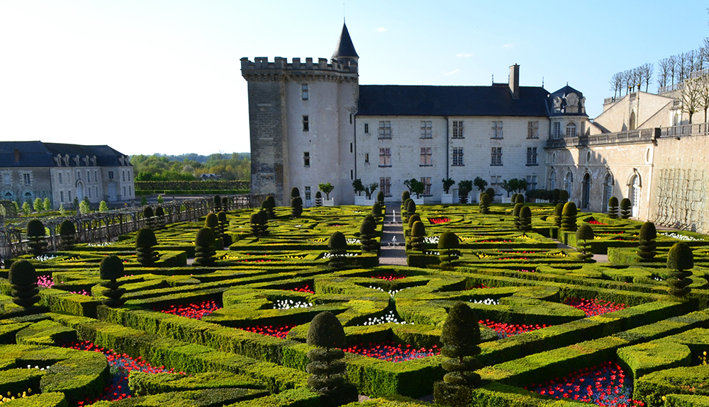 Rows of neat hedges and flowers are shown with Chateau de Villandry castle in the background