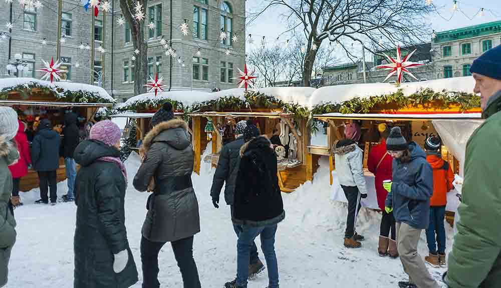 People in outdoor winter wear walking around the European-inspired market at the Marche de Noel Allemand de Quebec