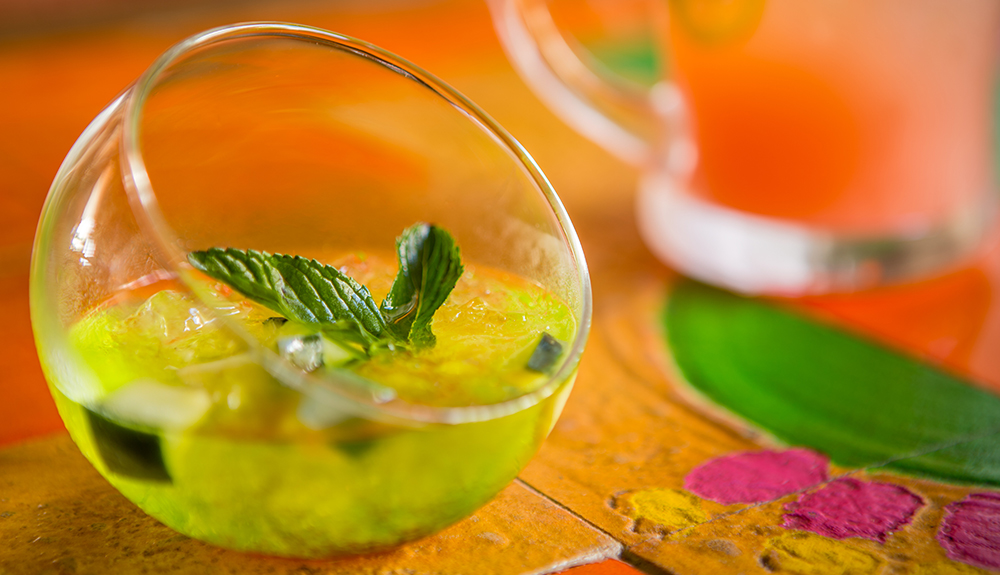 A unique glass holds a delicious Mexican cocktail on a wooden table