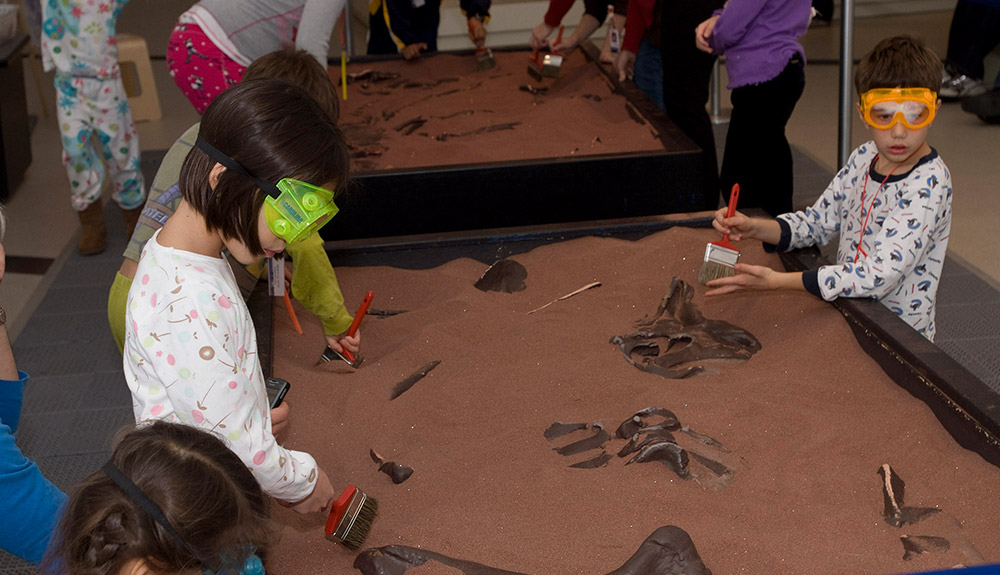 Kids in sleepwear playing with fossils at the Royal Ontario Museum