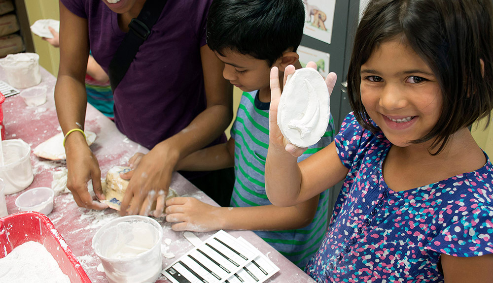 Little boy and little girl playing with fossil casting at the Royal Tyrell Museum
