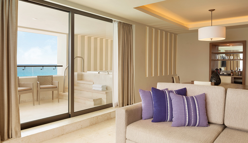 A view of a couch and balcony inside a family-friend suite at the Hyatt Ziva Cancun