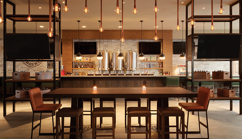 Empty table with modern light fixtures hanging from the ceiling in an adult-friendly dining spot on the resort