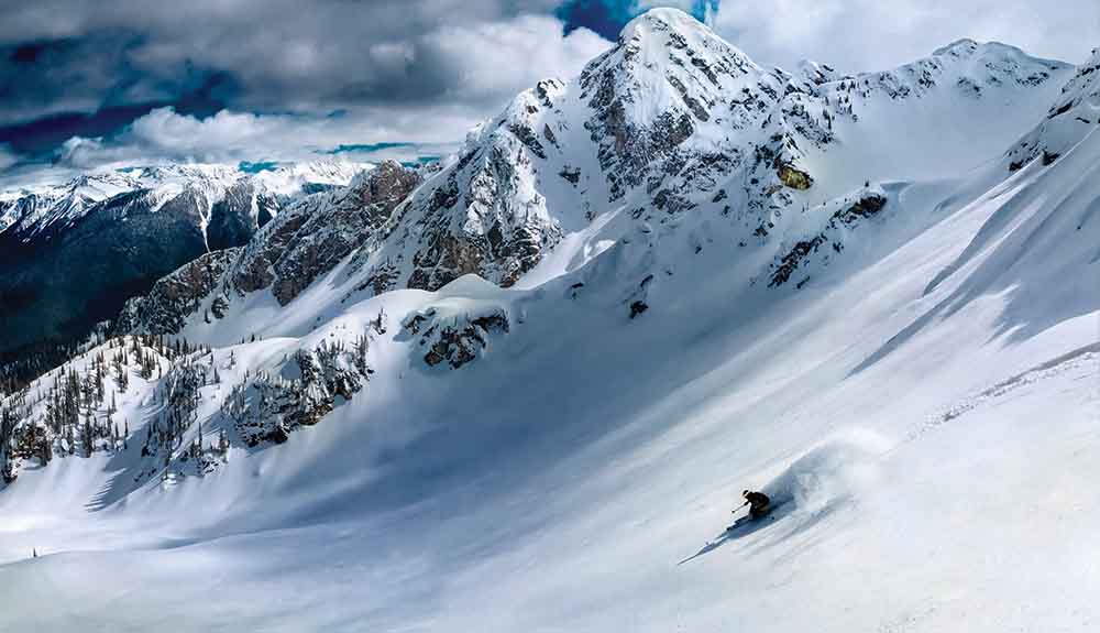 Single person skiing down the face of Revelstoke Mountain in British Columbia Canada