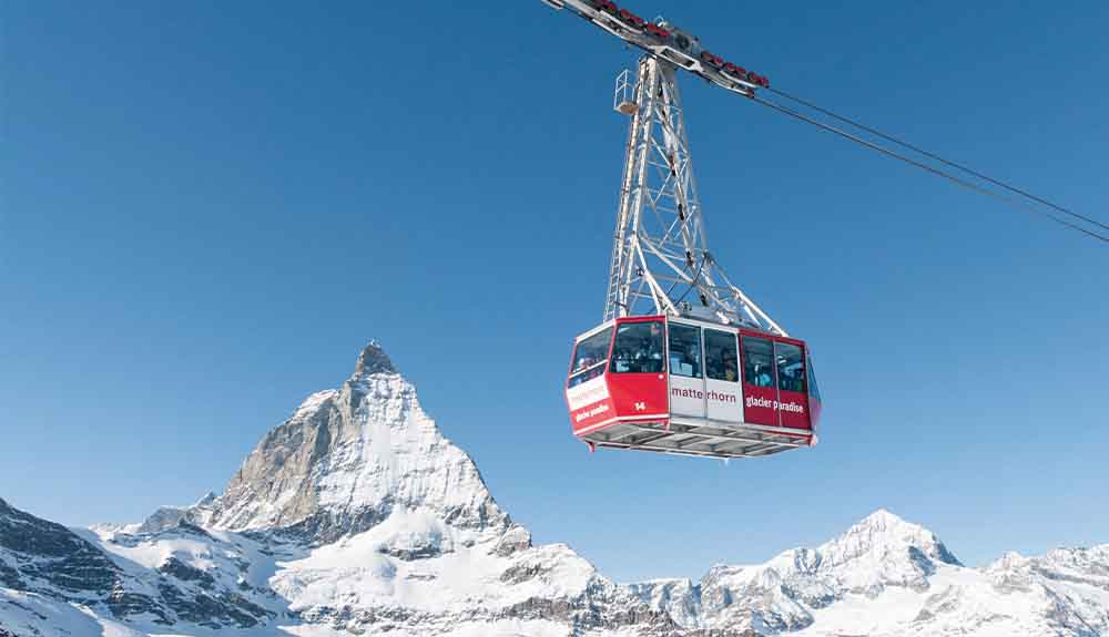 Red gondola passing over snowy peak at Big White ski resort in Canada