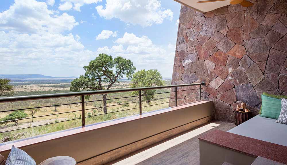 Looking out off the balcony at Serengeti National Park from this state-of-the-art lodge with a red rock wall